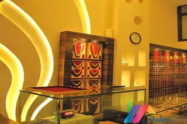 Jewellery display counters beside an illuminated gold feature wall.