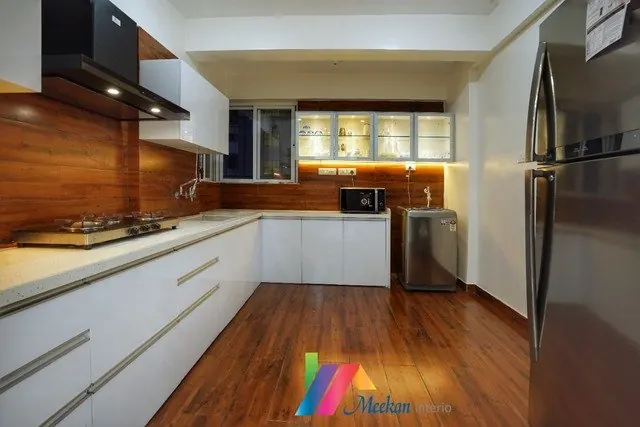 L-shaped kitchen with white drawers, timber wall cabinets and a black worktop.
