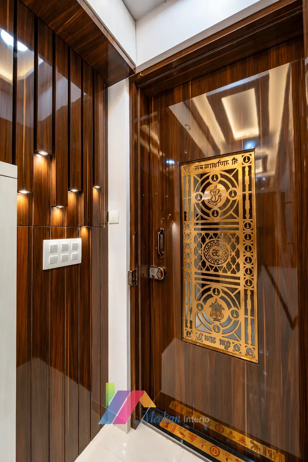 Timber entrance door with a gold decorative panel and illuminated wall detailing.