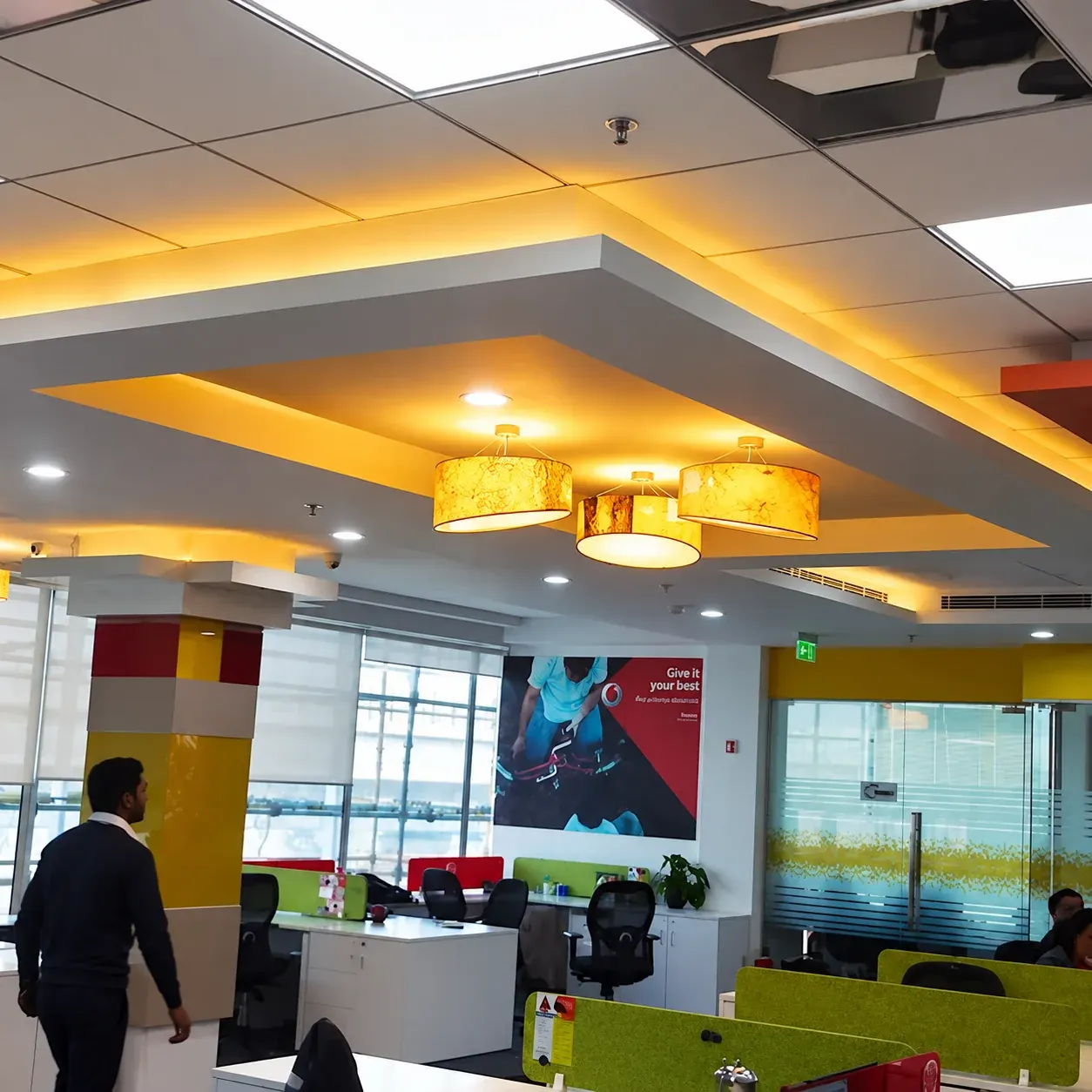 Office interior with warm pendant lights and layered ceiling detail.