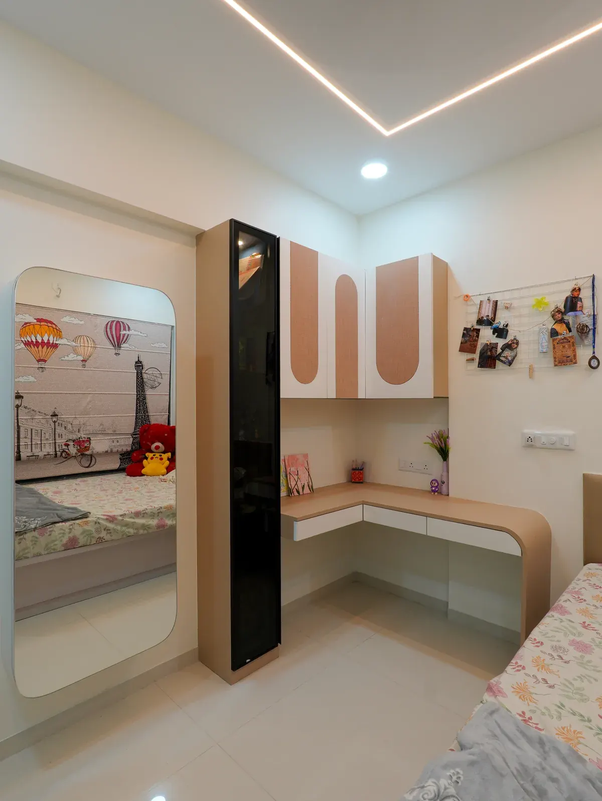 A built-in corner desk with overhead storage and a tall mirror beside the bed.