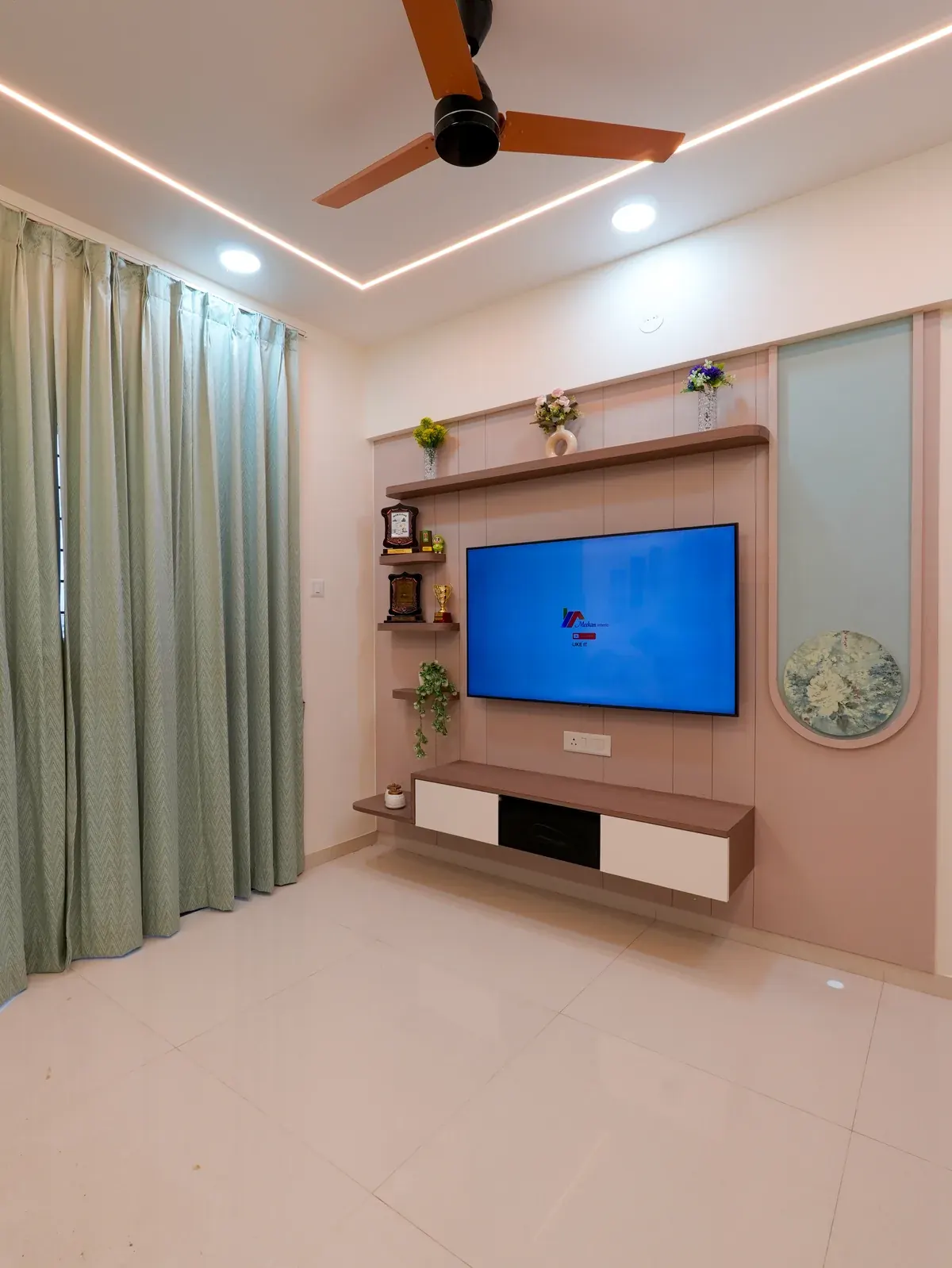 Living room television above a pale pink media unit beside full-height curtains.