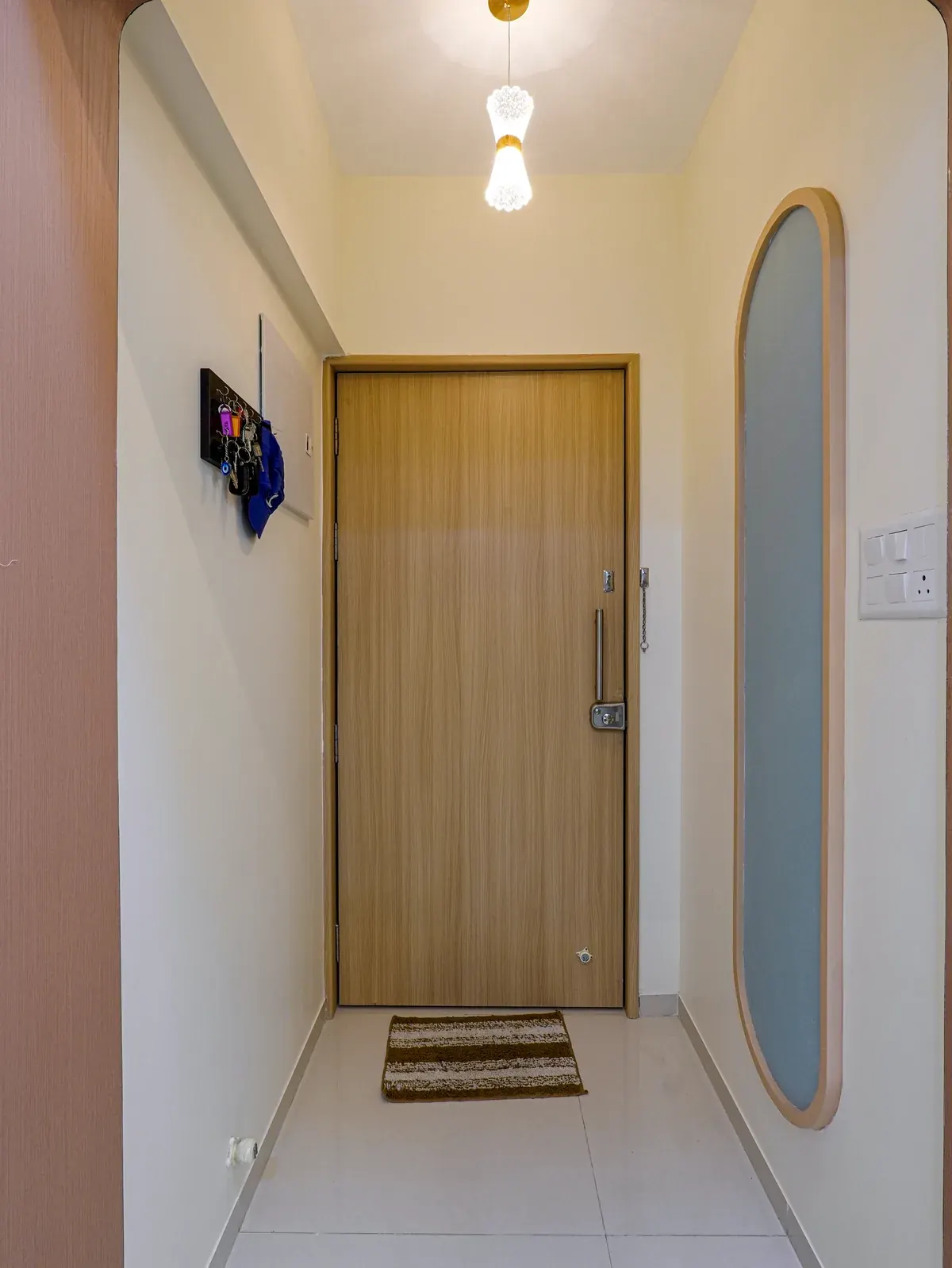 Entrance corridor with a timber door and oval wall mirror.